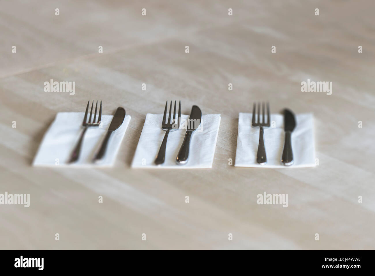 Posate su un tavolo in un ristorante coltelli forche tovaglioli tovaglioli Pulire gli utensili non utilizzati Foto Stock