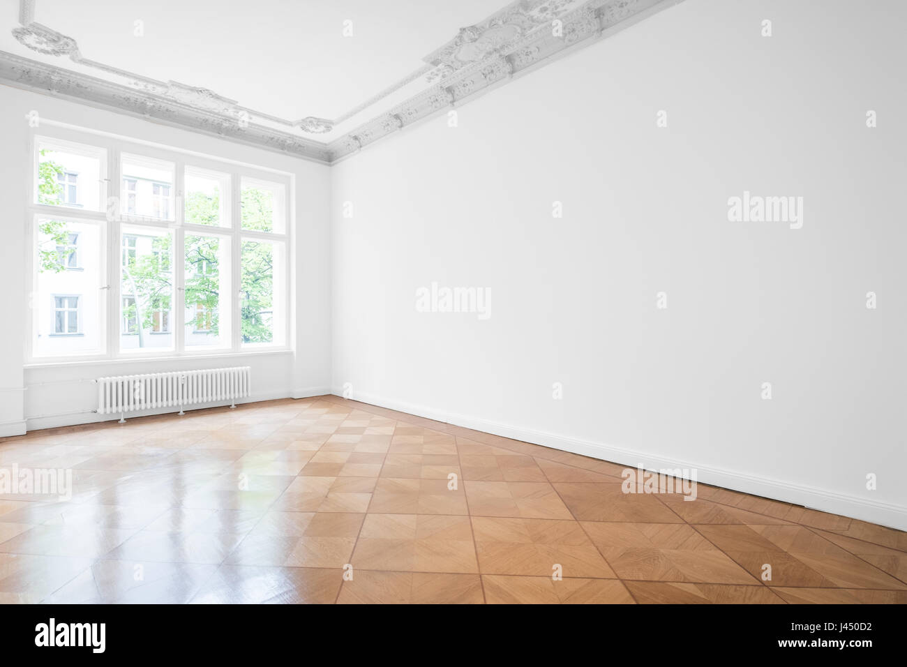 Stanza vuota con pavimenti in parquet , bianche pareti e soffitto in stucco - Nuovo appartamento in edificio storico Foto Stock