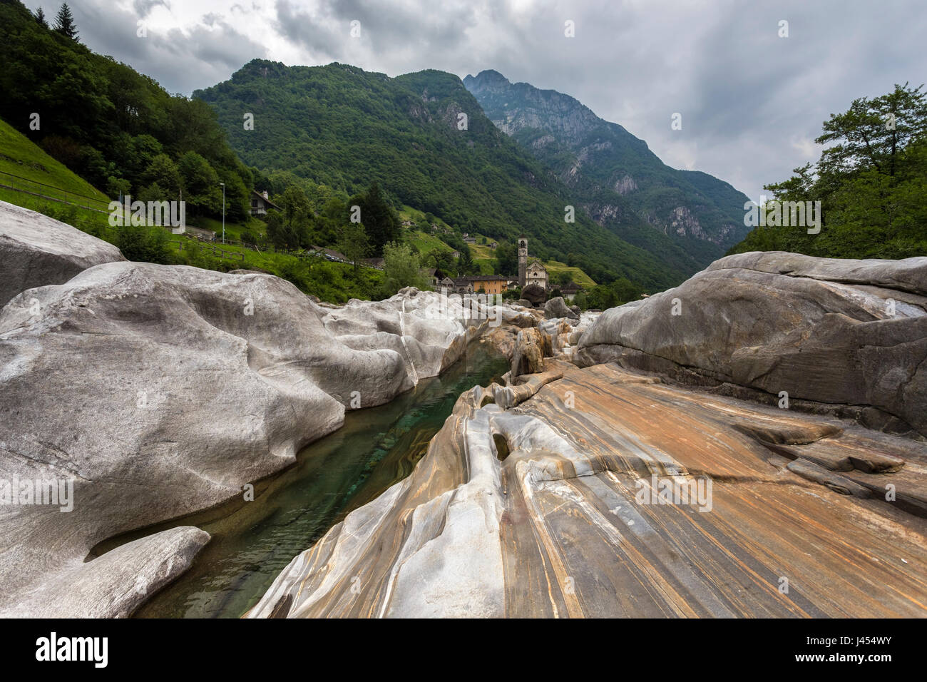 Le rocce sul letto del fiume Verzasca e la chiesa di Lavertezzo, Valle Verzasca, Canton Ticino, Svizzera. Foto Stock