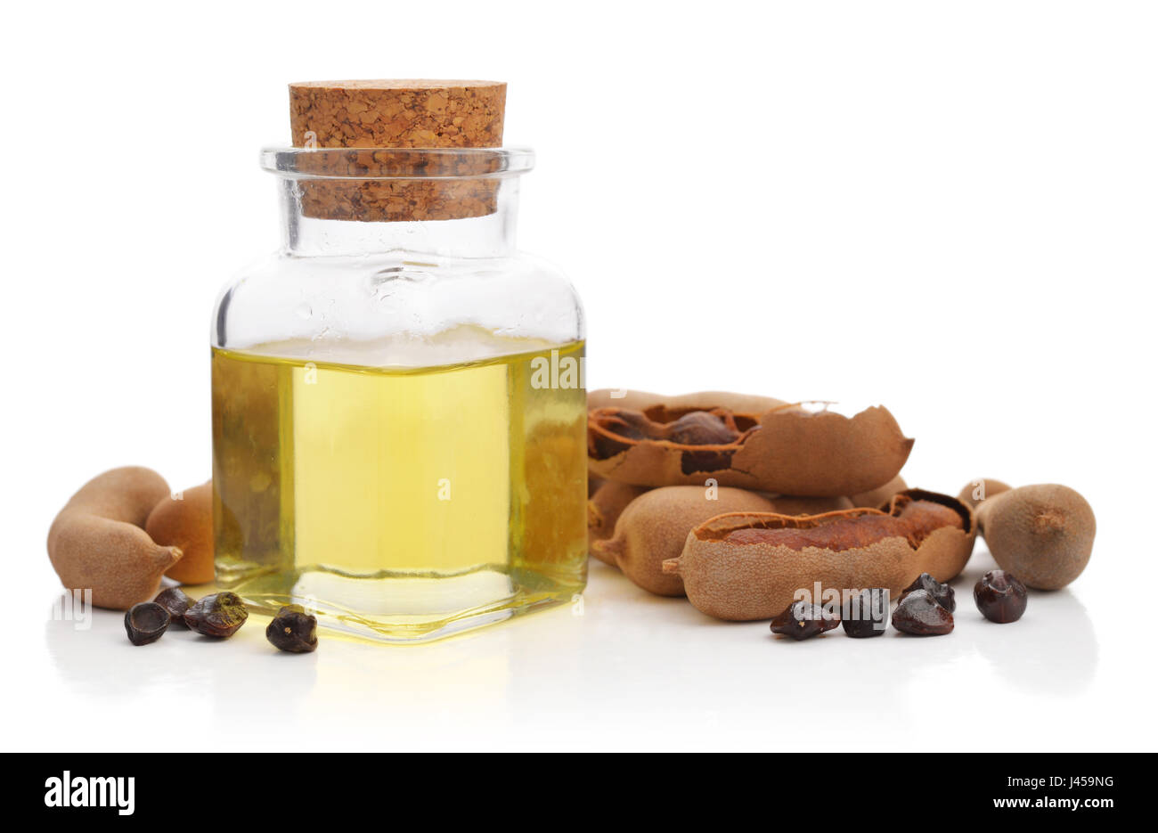 Essenziale olio di tamarindo con cialde di tamarindo isolati su sfondo bianco Foto Stock