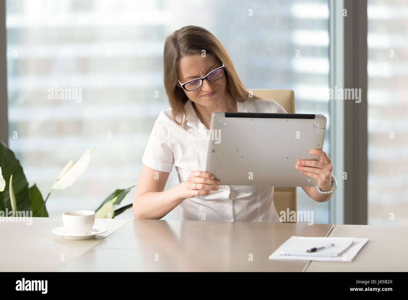Sottolineato femmina odia il suo vecchio computer portatile in ritardo di sviluppo Foto Stock
