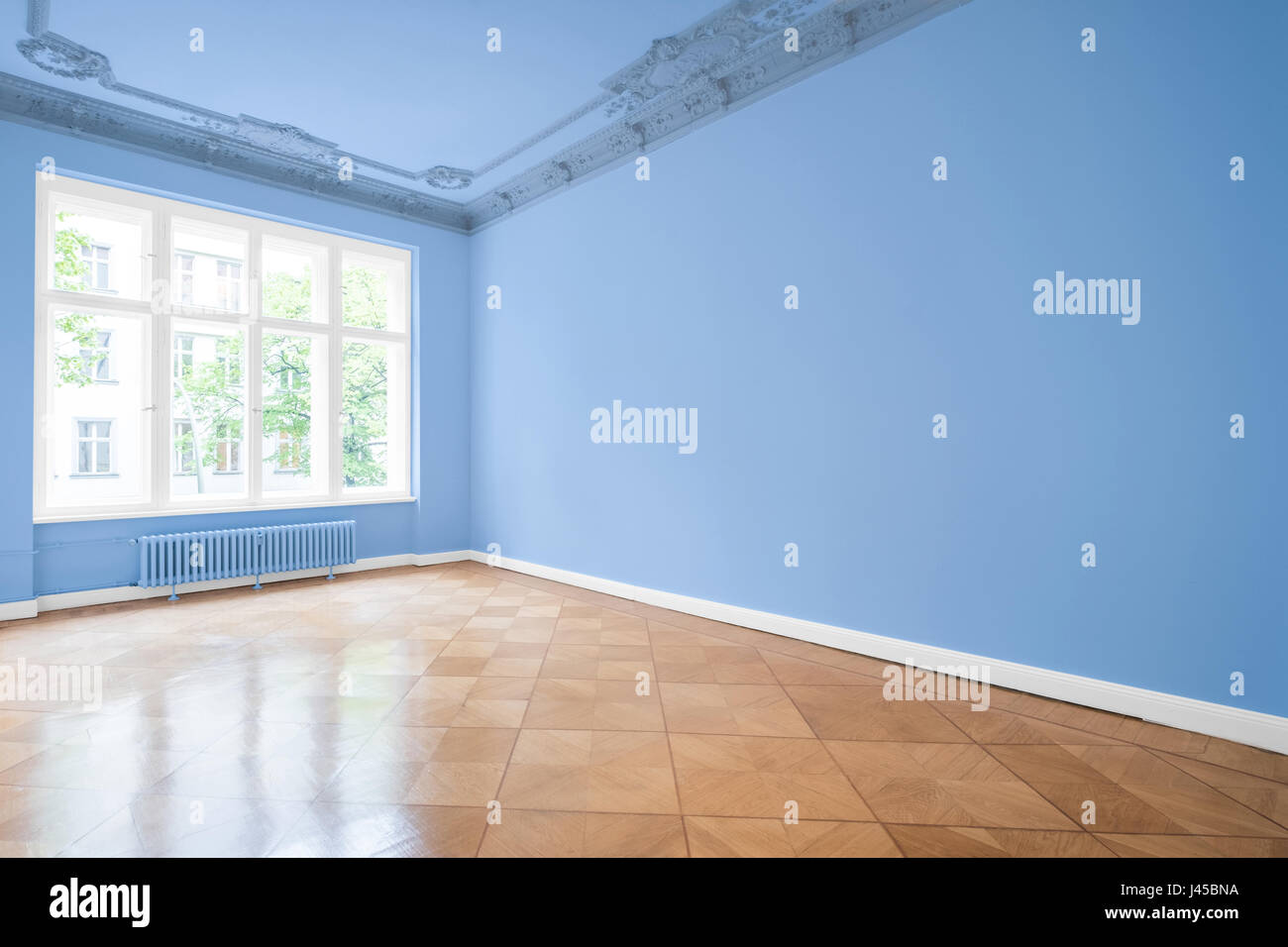 Stanza vuota nel nuovo appartamento con pareti blu e pavimento in legno Foto Stock