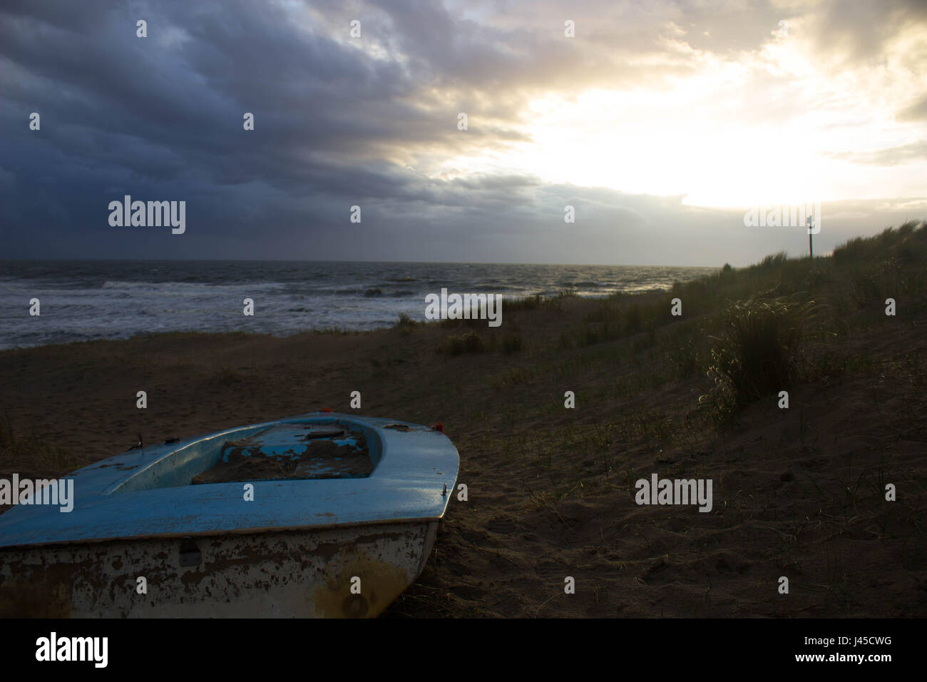 Piccola barca di fronte al mare del Nord a destra dopo una tempesta Foto Stock