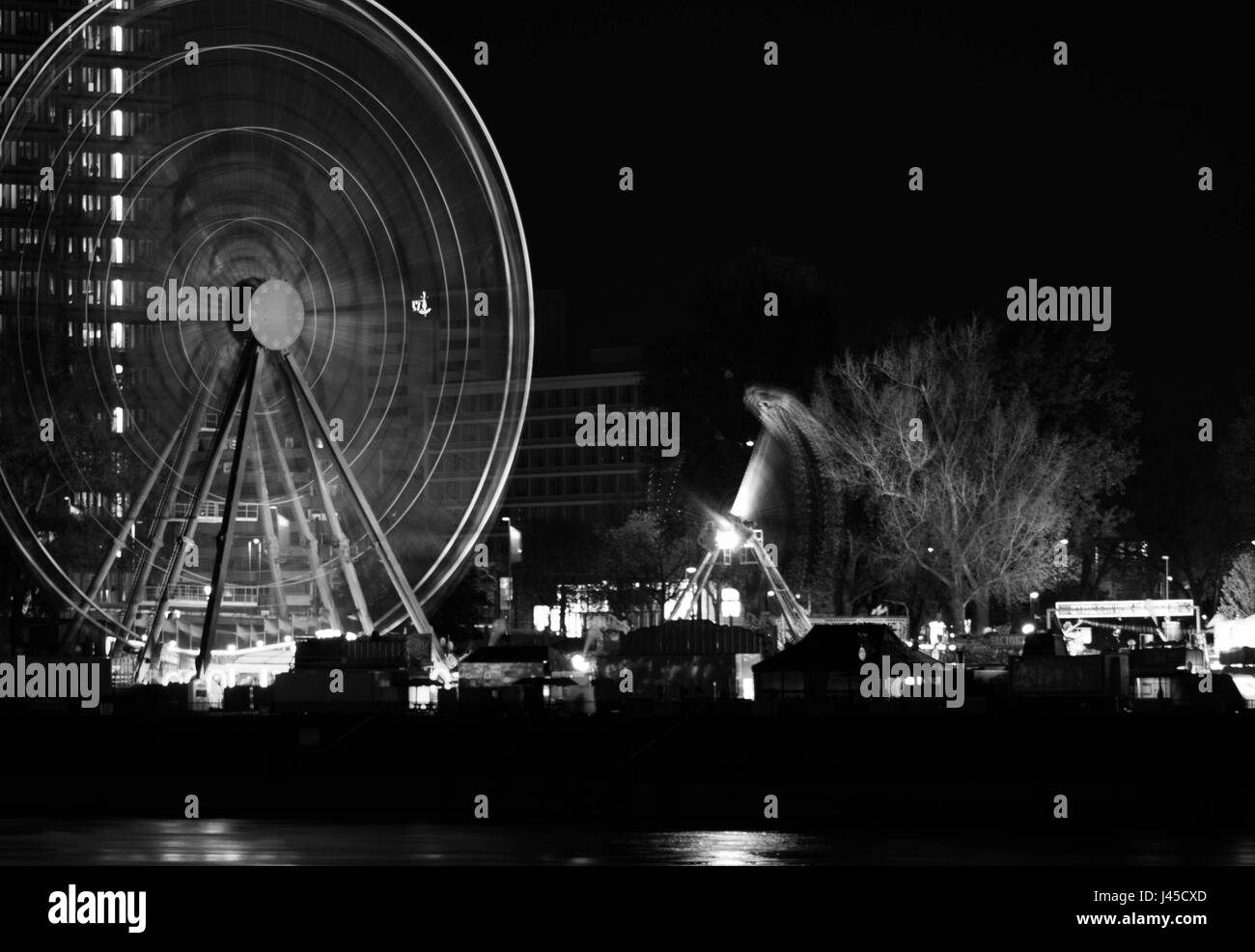 Bianco e nero ruota panoramica Ferris di notte in movimento Foto Stock