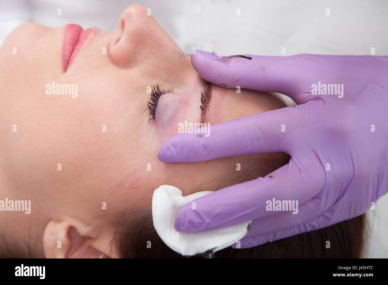 Cosmetologo applicare trucco permanente sulle sopracciglia Foto Stock