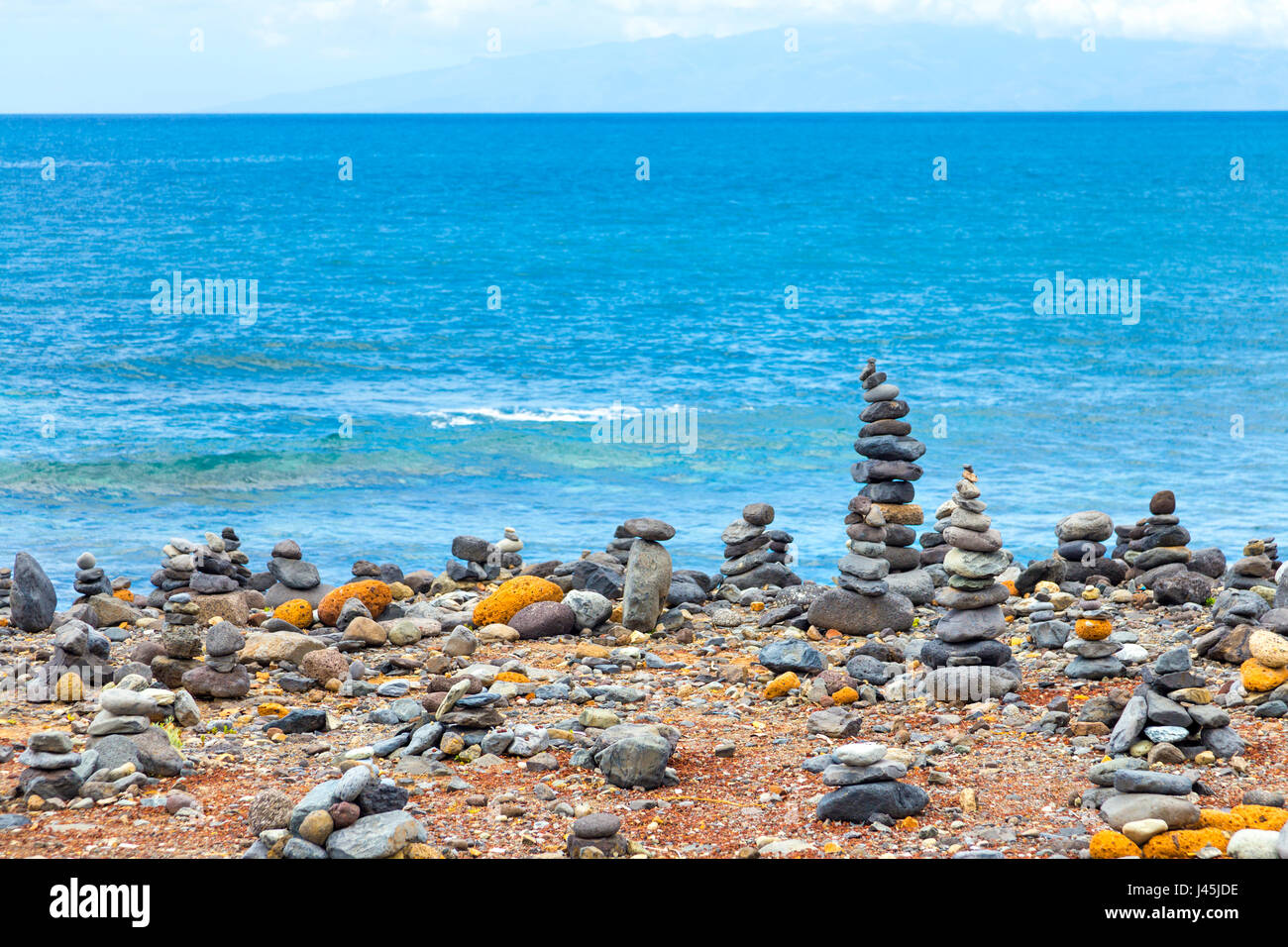 Rocce equilibrato su una spiaggia con l'oceano sullo sfondo a Tenerife, Spagna Foto Stock