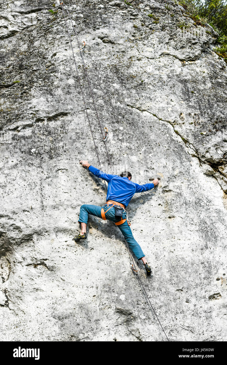 Giovane maschio scalatore scalata di un percorso su una roccia. Jura krakowsko chestochowska. Foto Stock
