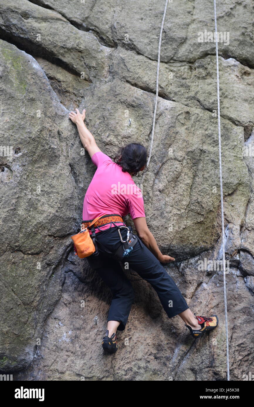 Femmina giovane scalatore scalata di un percorso su una roccia. Sokoliki, Polonia Foto Stock