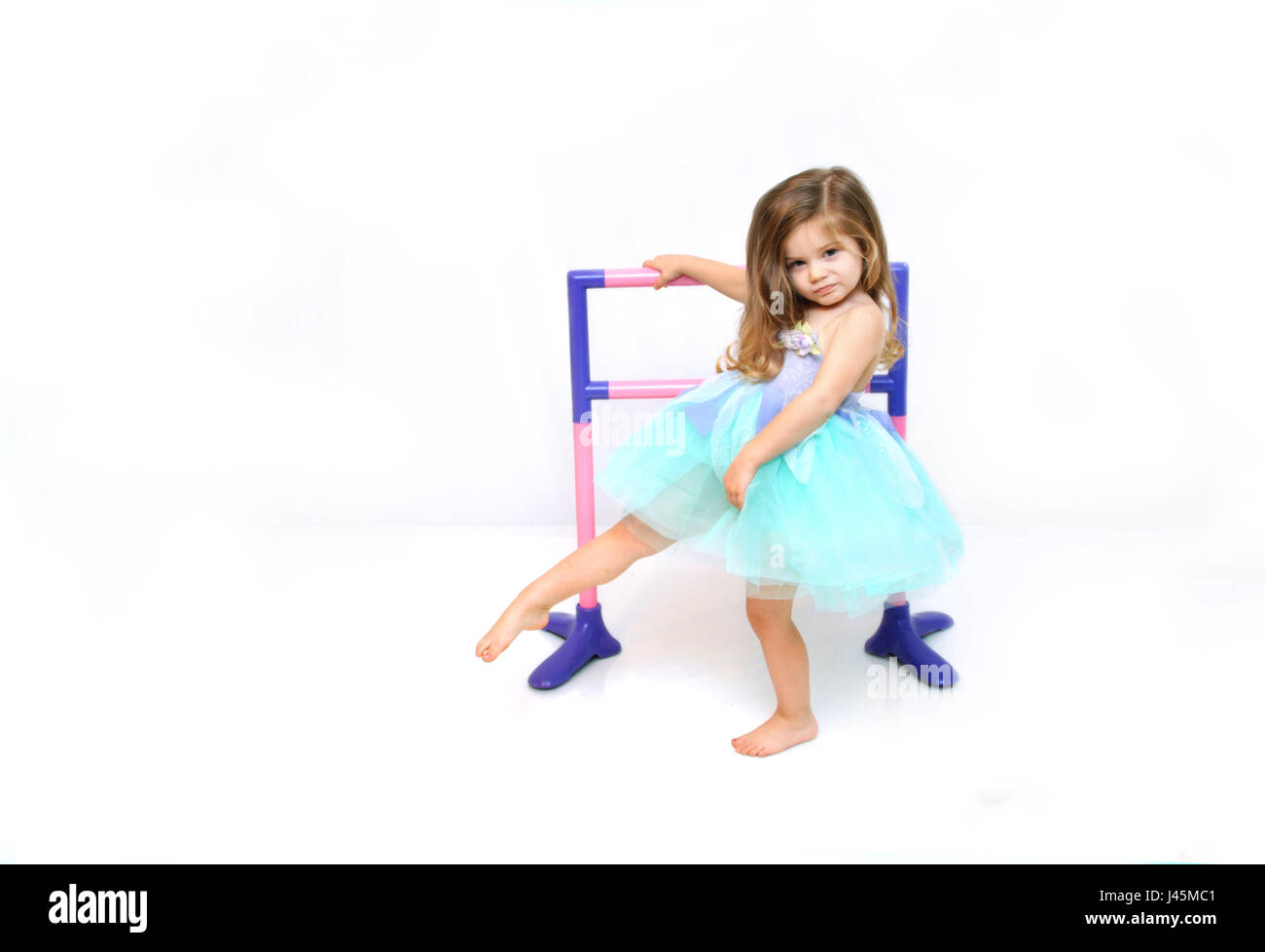 Bellissima bambina pratiche e si estende per la sua danza di routine. ella  è vestito in un costume da ballerina di aqua e lilla Foto stock - Alamy
