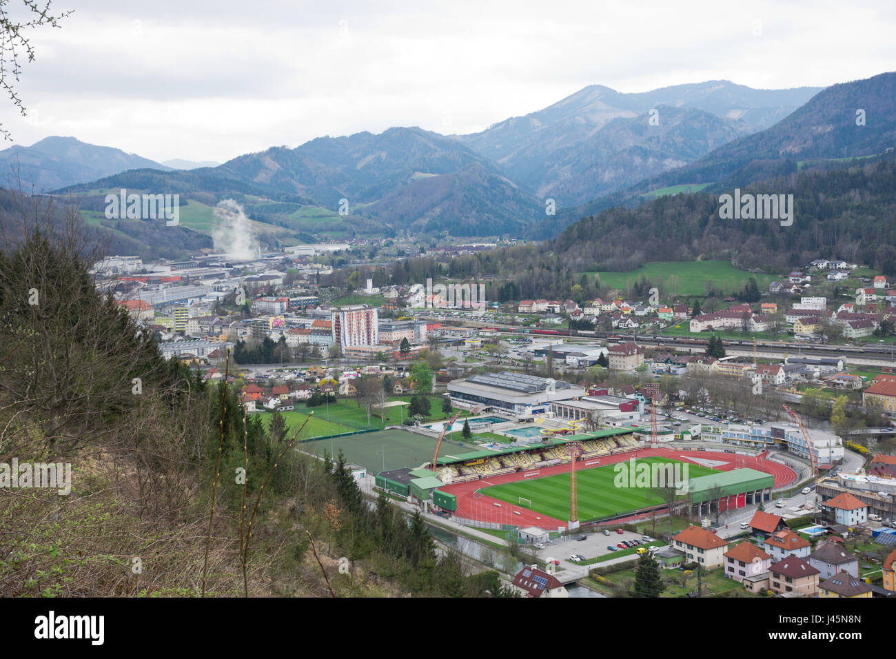 Panoramica di Kapfenberg in Stiria, visto da sud. Significativo impianto di produzione dell'industria siderurgica. Foothills boscosi in background. Foto Stock