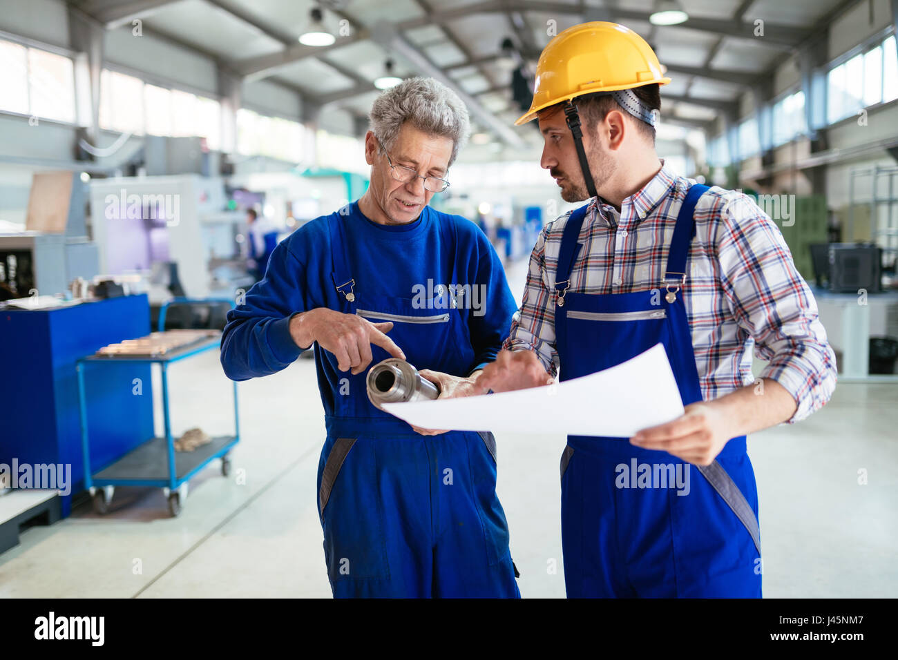 Meccanica e industria del metallo gli ingegneri che lavorano in fabbrica Foto Stock