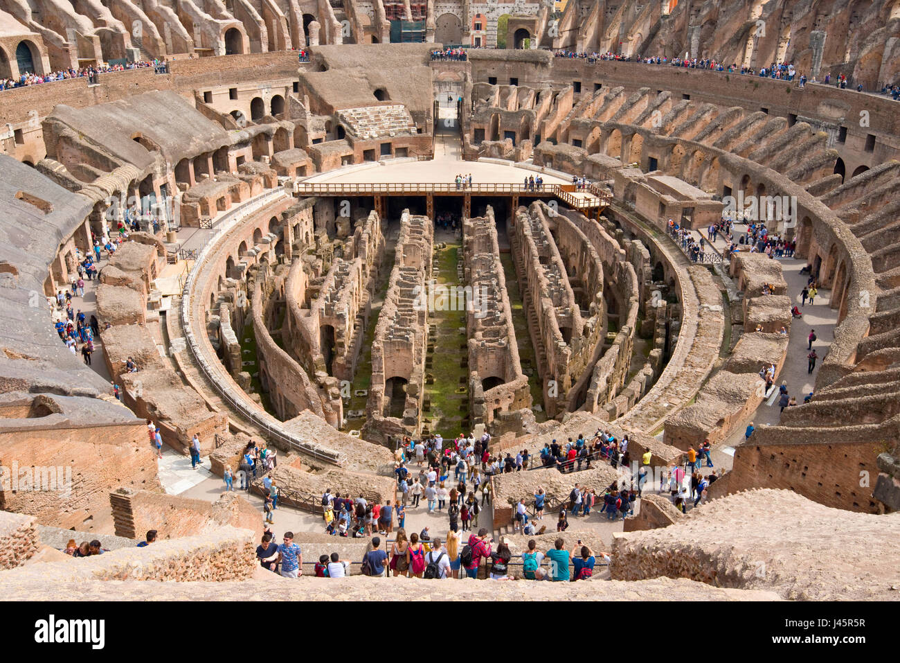 Un ampio angolo di vista interna dell'anfiteatro all'interno del Colosseo con i turisti i visitatori in una giornata di sole con cielo blu preso dal livello superiore 3. Foto Stock