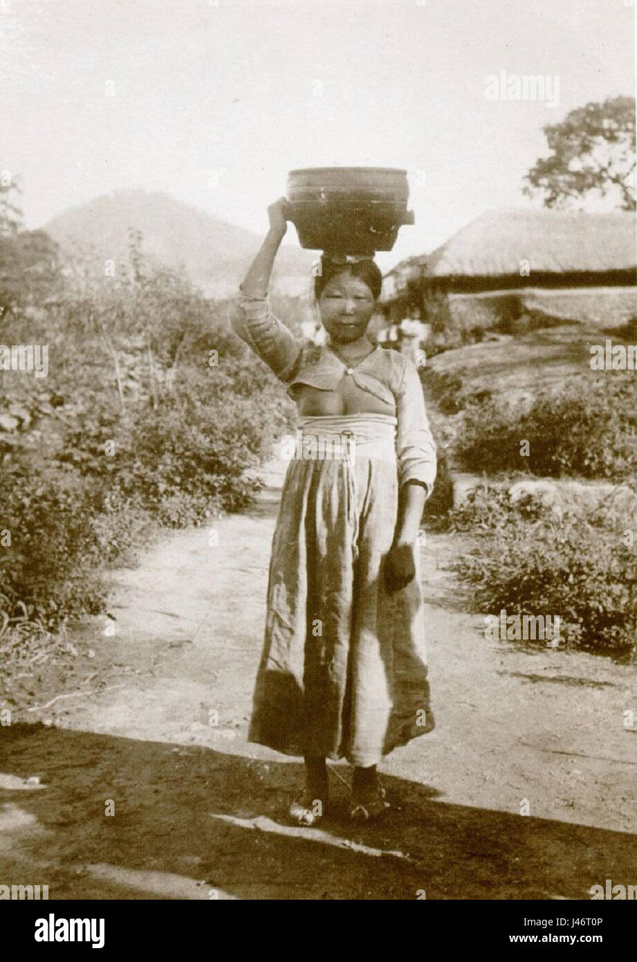 Questa immagine di un'anziana donna coreana probabilmente cattura l'essenza della cultura tradizionale coreana. Il soggetto è una rappresentazione della generazione più anziana, che riflette i valori, la saggezza e l'esperienza tramandate attraverso le famiglie e la società coreane. Foto Stock