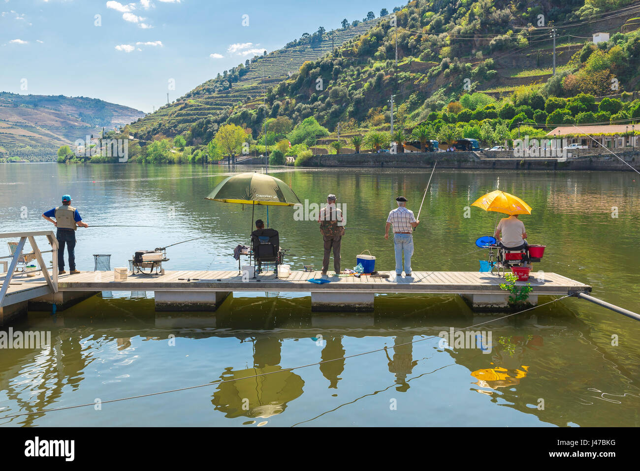 Valle del Douro in Portogallo, gli uomini la pesca sul fiume Douro dal molo del porto wine town di Pinhao, Portogallo Foto Stock