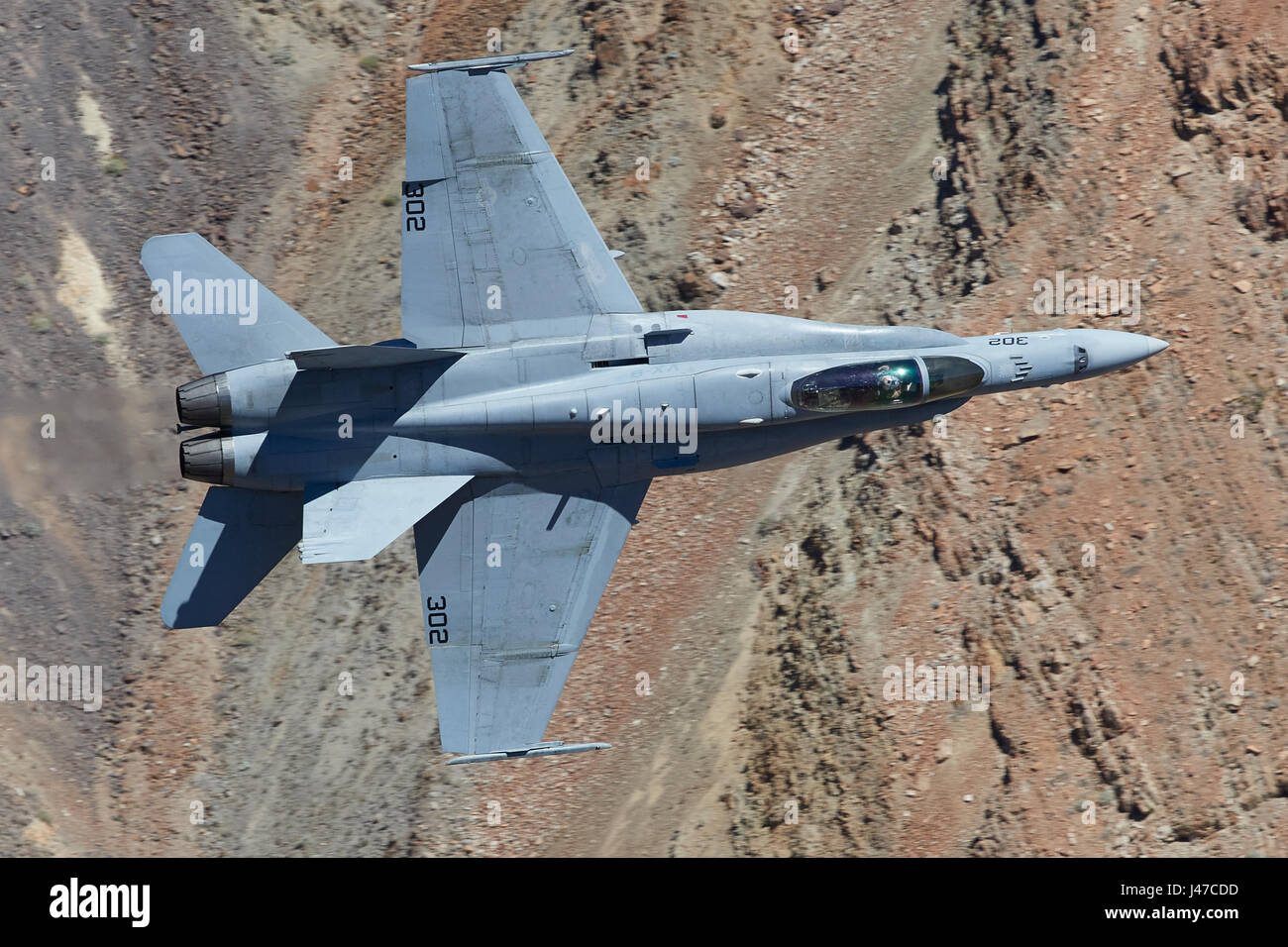 Marina degli Stati Uniti F/A-18C, Hornet, volare ad alta velocità e a basso livello. Attraverso un canyon del deserto. Foto Stock