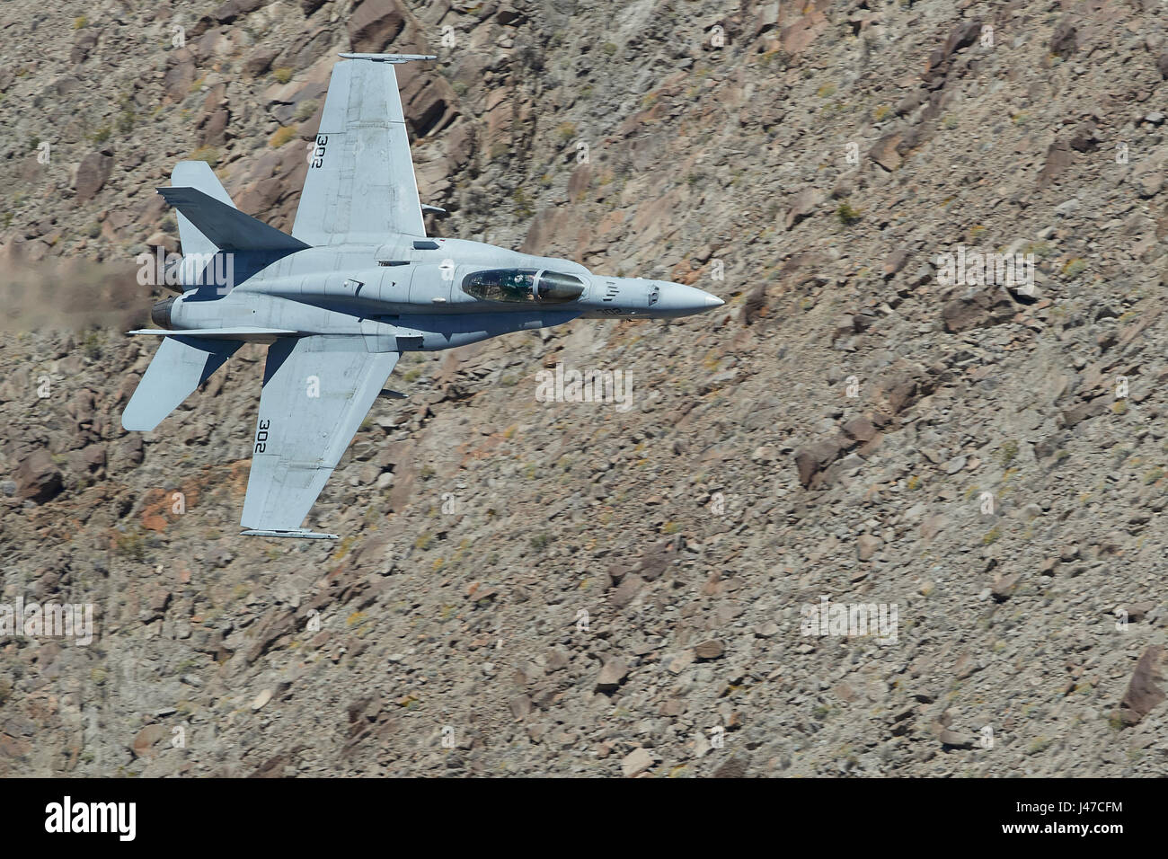 Marina degli Stati Uniti F/A-18C, Hornet, volare ad alta velocità e a basso livello. Attraverso un canyon del deserto. Foto Stock