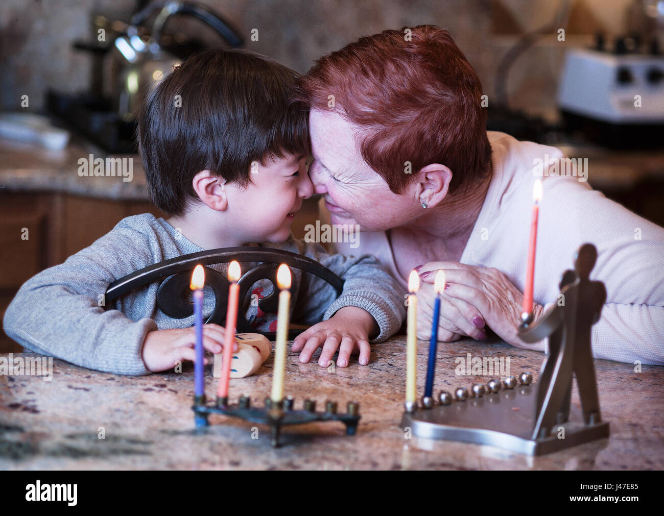 Famiglia ebraica di nonni e nipote Hanukkah illuminazione candele in un menorah per la holdiays Foto Stock