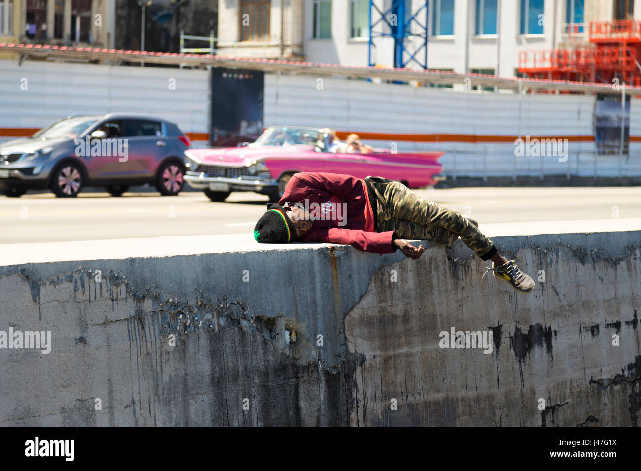 Giovane uomo prendendo un pisolino al Malecon, Havana, Cuba Foto Stock