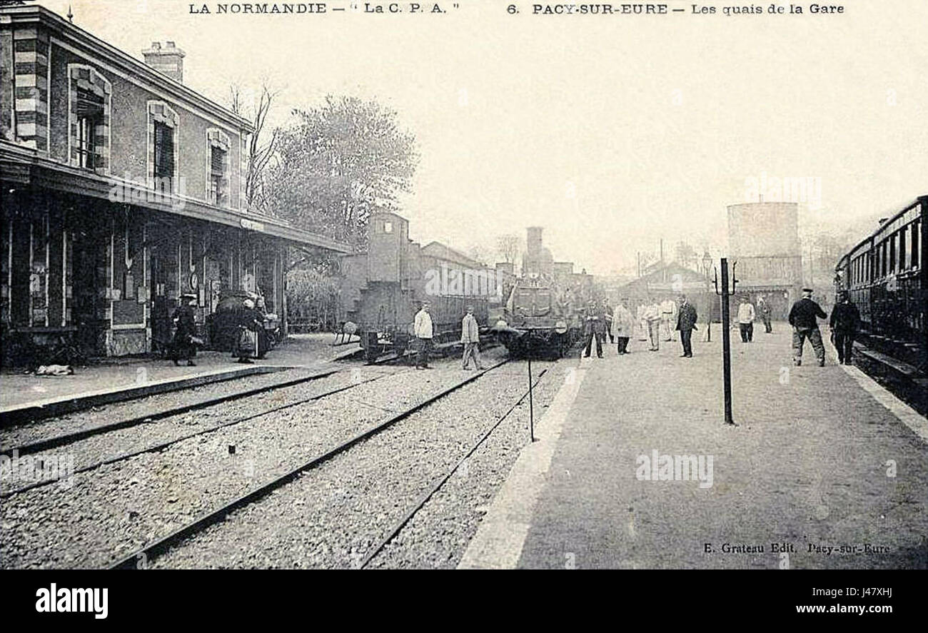 Pacy-sur-Eure è un comune francese della regione della Normandia. "Les quais de la gare" si riferisce alle piattaforme della stazione ferroviaria, parte integrante delle infrastrutture di trasporto della città e della storia locale. Foto Stock