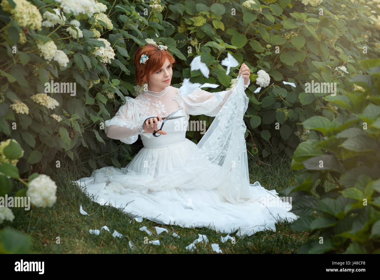 La ragazza in un abito da sposa tagliare lo stile di rifusione. Foto Stock
