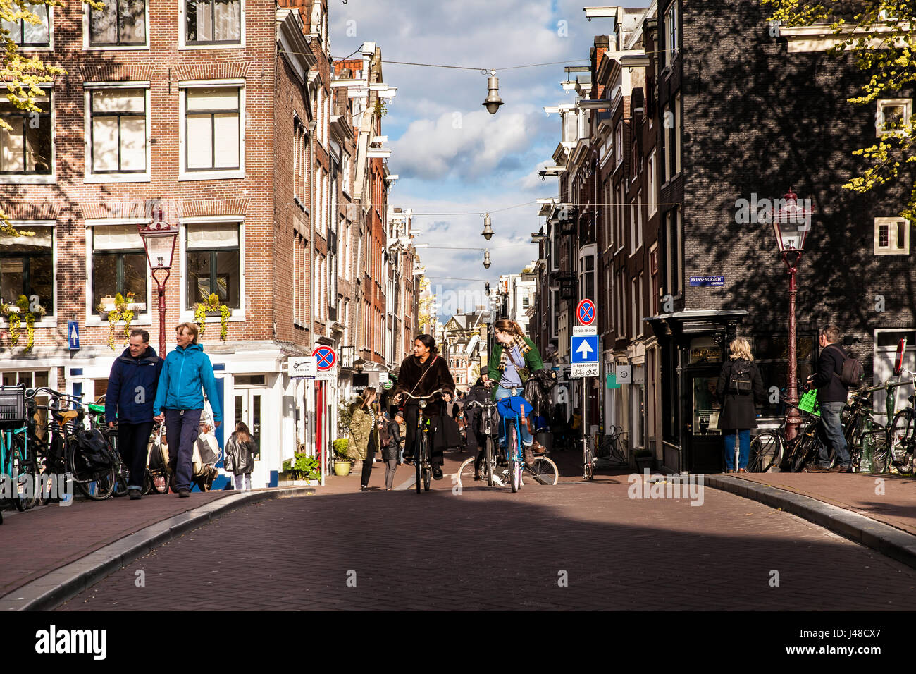 Alla gente del posto per le biciclette su strada di Amsterdam. Giornata di Primavera il triidrato di alluminio la città Foto Stock