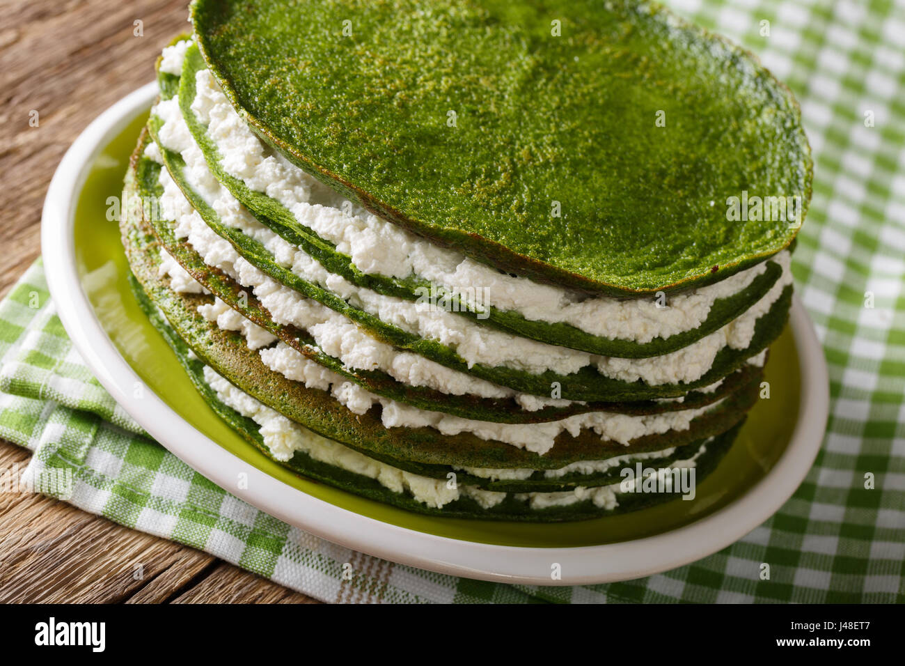 Snack torta fatta di spinaci crepes con ricotta close-up su una piastra orizzontale. Foto Stock