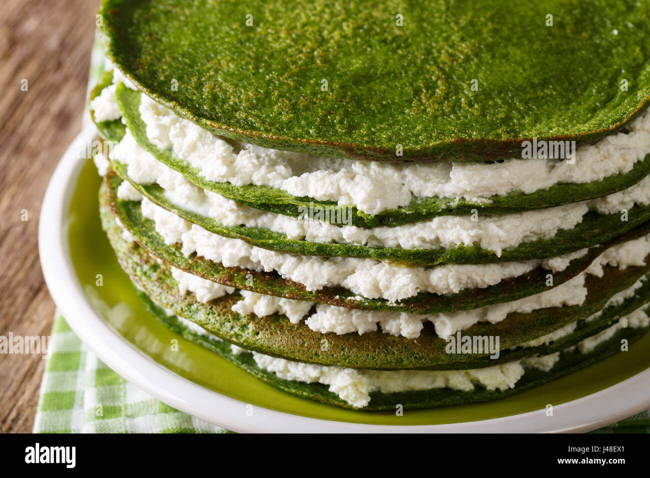 Cibo sano: spinaci crepes torta con crema al formaggio close-up su una piastra orizzontale. Foto Stock