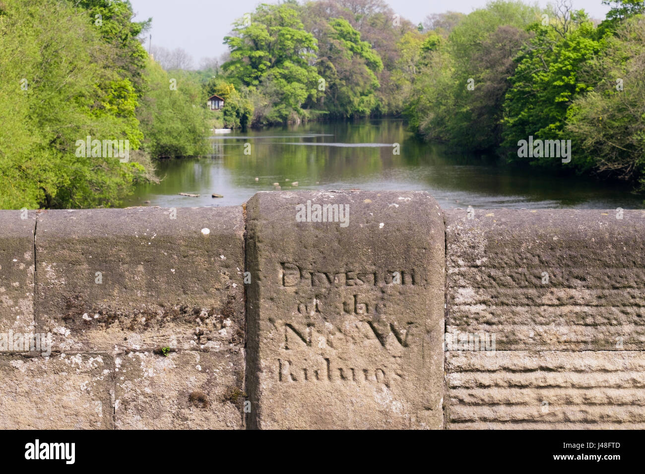 Il vecchio segno inciso nel ponte di pietra sul Fiume Ure marcatura di confine tra il nord e l ovest circoscrizioni. West Tanfield, North Yorkshire, Inghilterra, Regno Unito, Gran Bretagna Foto Stock