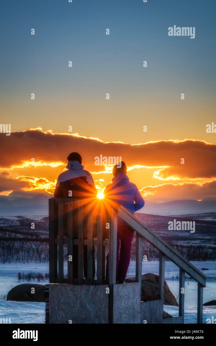 Giovane godendo di un tramonto in inverno, Lapponia, Svezia Foto Stock