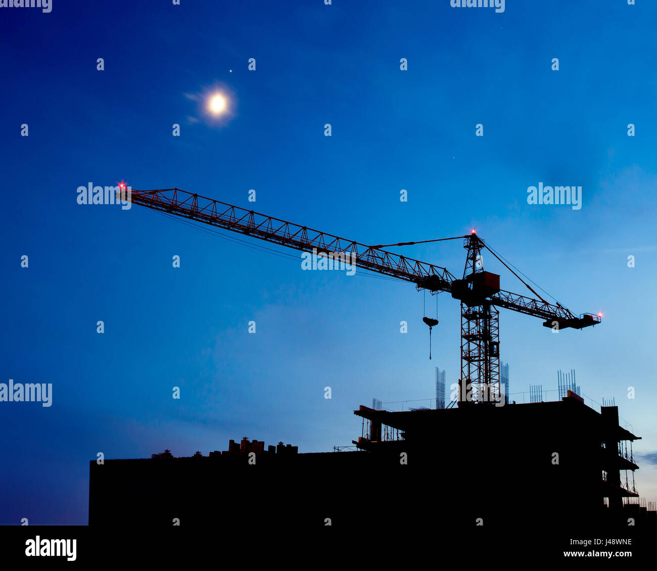 Sito in costruzione. Industrial gru per edilizia e costruzione di sagome sul cielo notturno. Bella colorato paesaggio notturno. Foto Stock