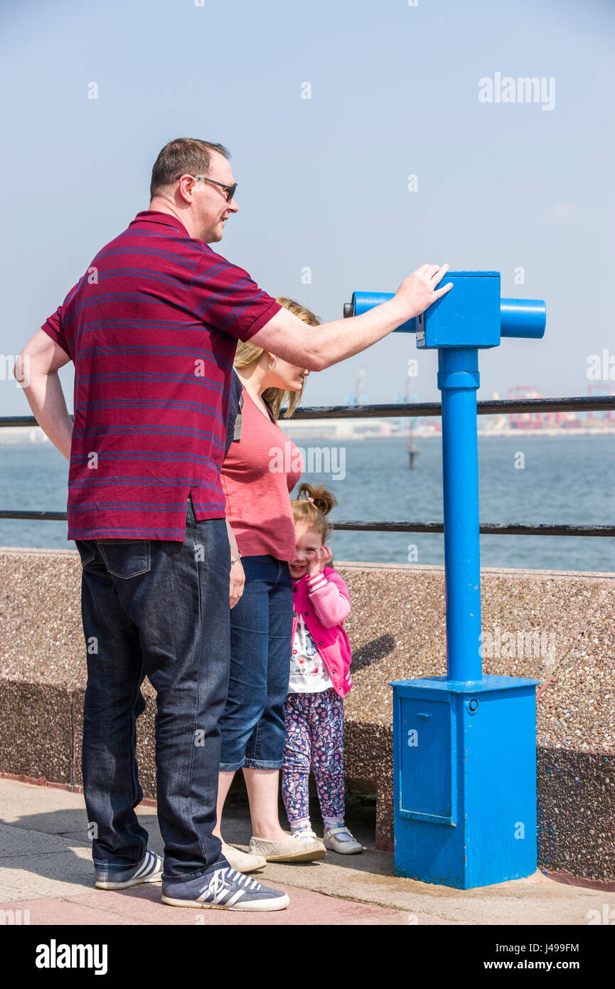 New Brighton, Wirral, Regno Unito. 11 Maggio, 2017. Una famiglia guardare attraverso un telescopio attraverso il fiume Mersey per Liverpool, come persone che si godono la continua soleggiato e caldo, meteo davanti a ciò che è previsto per essere un luogo fresco e umido, weekend. © Paul Warburton Foto Stock