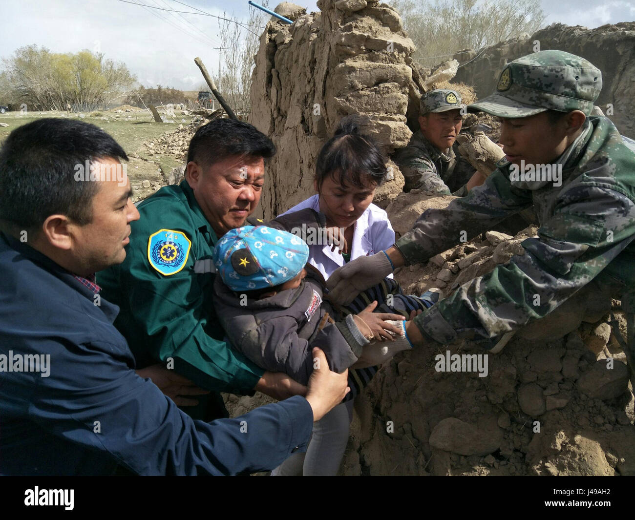 Taxkorgan cinese Xinjiang Uygur Regione autonoma. 11 Maggio, 2017. Soccorritori salva un ragazzo di Tajik gruppo etnico nel villaggio Quzgun in quake-hit Taxkorgan County, a nord-ovest della Cina di Xinjiang Uygur Regione autonoma, 11 maggio 2017. Otto morti sono state confermate e 23 feriti dopo il terremoto nella contea di Taxkorgan, Xinjiang, a 5:58 a.m. Giovedì. Ha inoltre portato a gravi danni o il crollo di 1.520 case. Credito: Yue Xiaoping/Xinhua/Alamy Live News Foto Stock