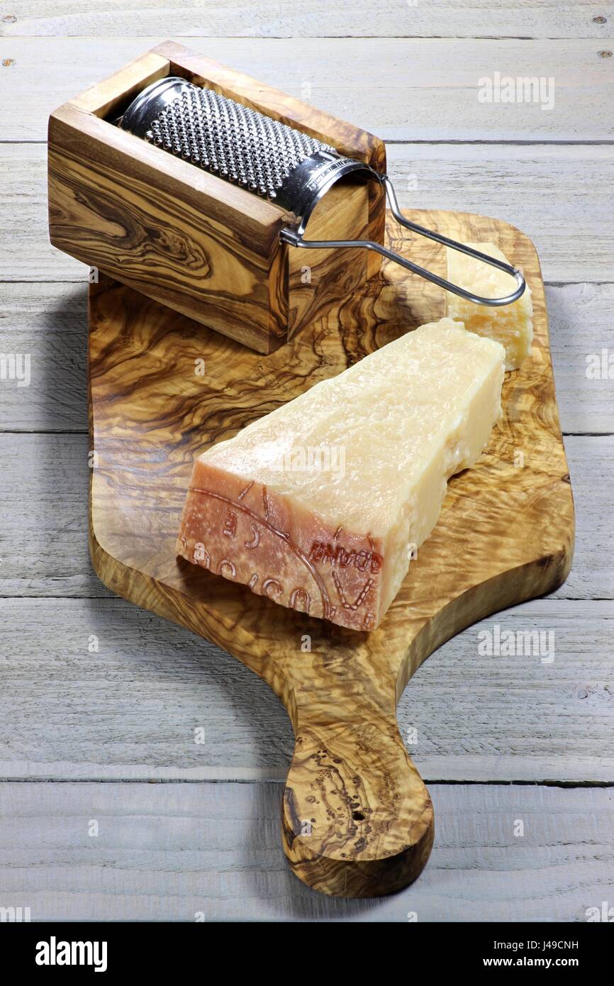 Formaggio duro italiano con grattugia su sfondo di legno Foto Stock