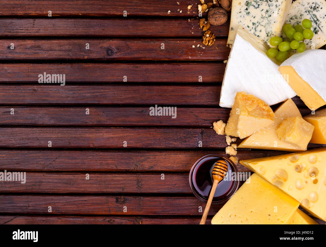Vari tipi di formaggio su un tavolo di legno dello sfondo. Il Cheddar, parmigiano, emmental, formaggi blu. Vista superiore, copia dello spazio. Foto Stock