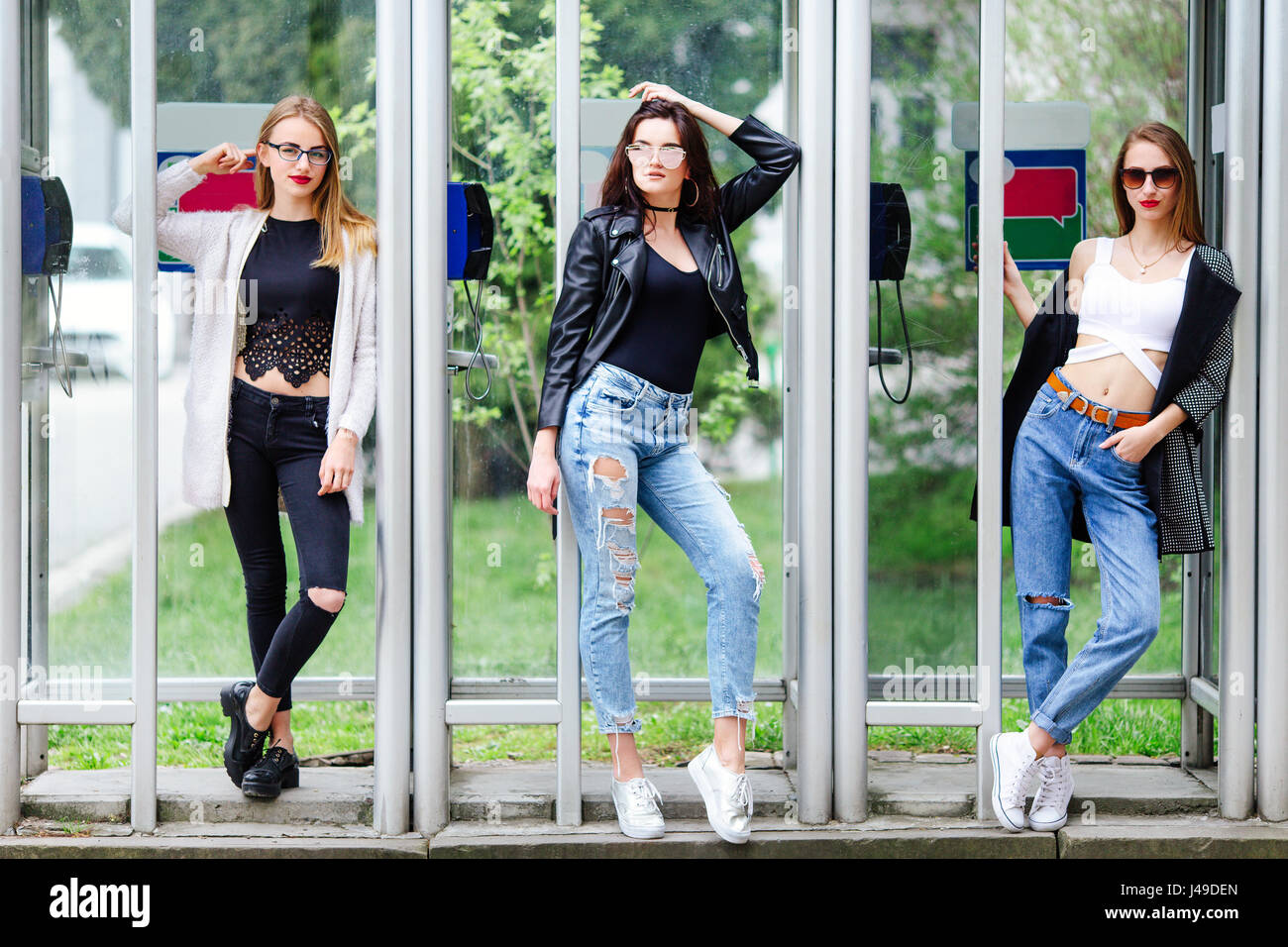 Tre ragazza supporto vicino alla casella Chiamata con sfondo verde primavera Foto Stock