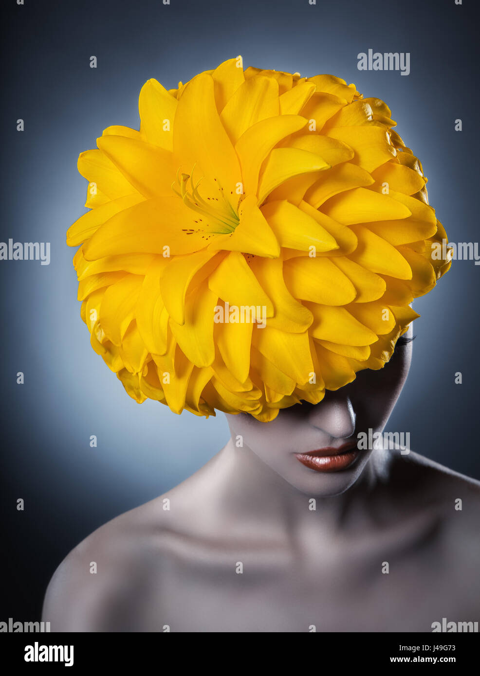 Ritratto di una bellissima ragazza con un fiore giallo dei capelli. Modello di moda Foto Stock