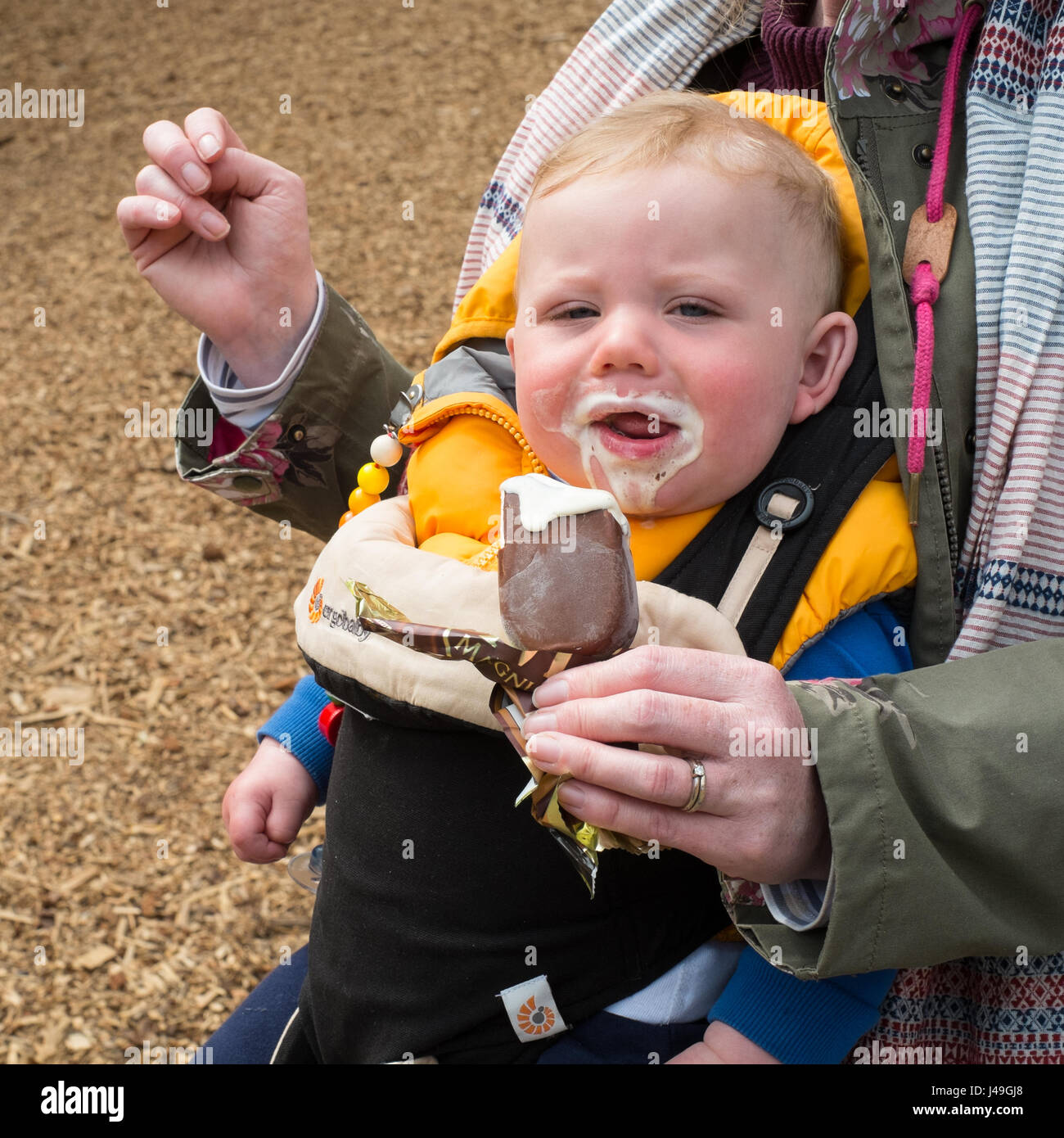 Otto mesi di età bambino mangiare un gelato al Woodlands Family Theme Park, Totnes, Devon , in Inghilterra, Regno Unito Foto Stock