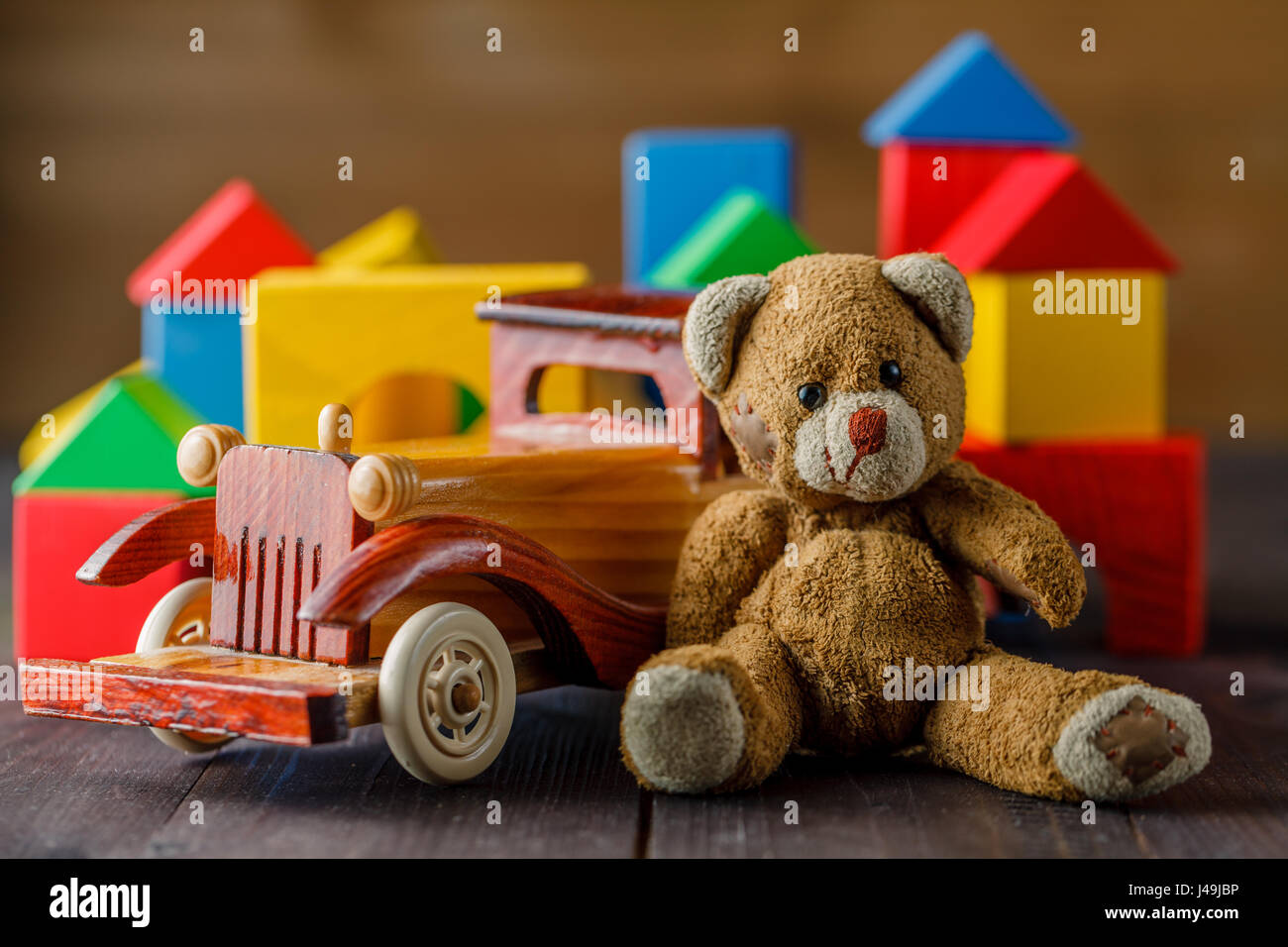 Casa fatta di blocchi di legno per assemblare, vicino atoy e un giocattolo di legno auto Foto Stock