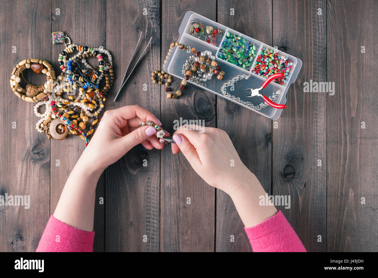 Realizzazione di gioielli fatti a mano. Scatola con talloni sul vecchio  sfondo di legno. Accessori fatti a mano. Vista superiore Foto stock - Alamy