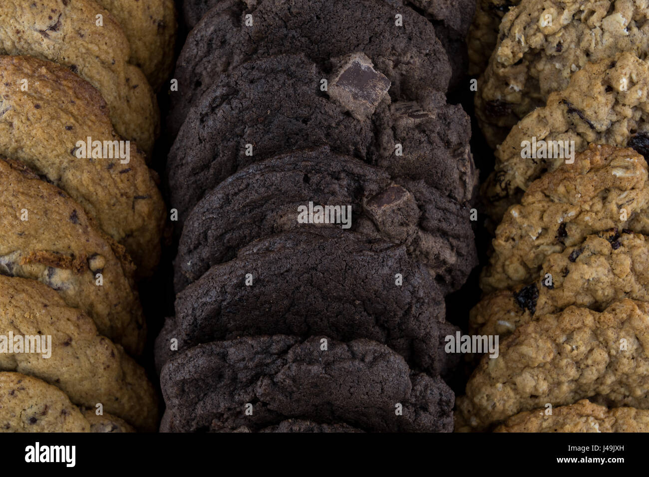 Guardando verso il basso su righe di biscotti assortiti con doppio biscotti al cioccolato in medio Foto Stock