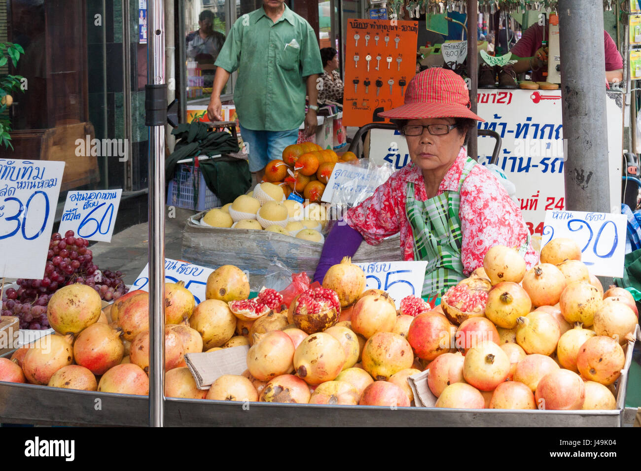 Fornitore di donna street market di stallo frutto di melograno, Bangkok, Thailandia Foto Stock