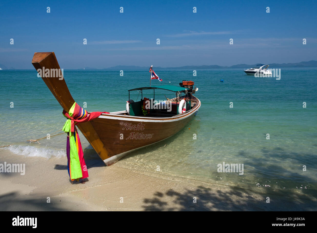 Barca dalla coda lunga con power boat in background su Koh Naka, isola di Phuket, Tailandia Foto Stock