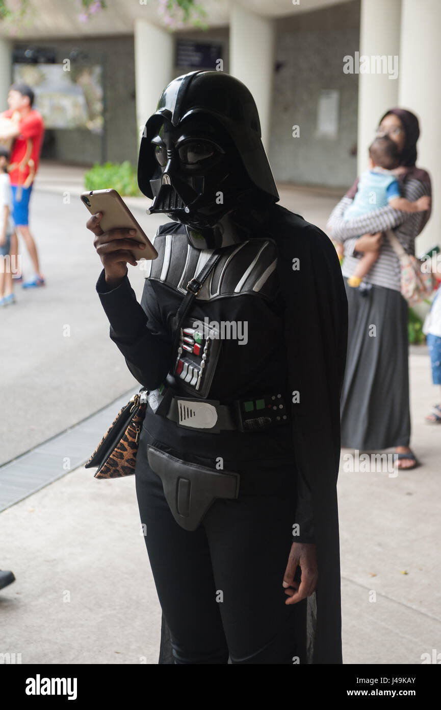 06.05.2017, Singapore, Repubblica di Singapore, in asia - una donna vestita di un Darth Vader costume è visto usando il suo smartphone. Foto Stock