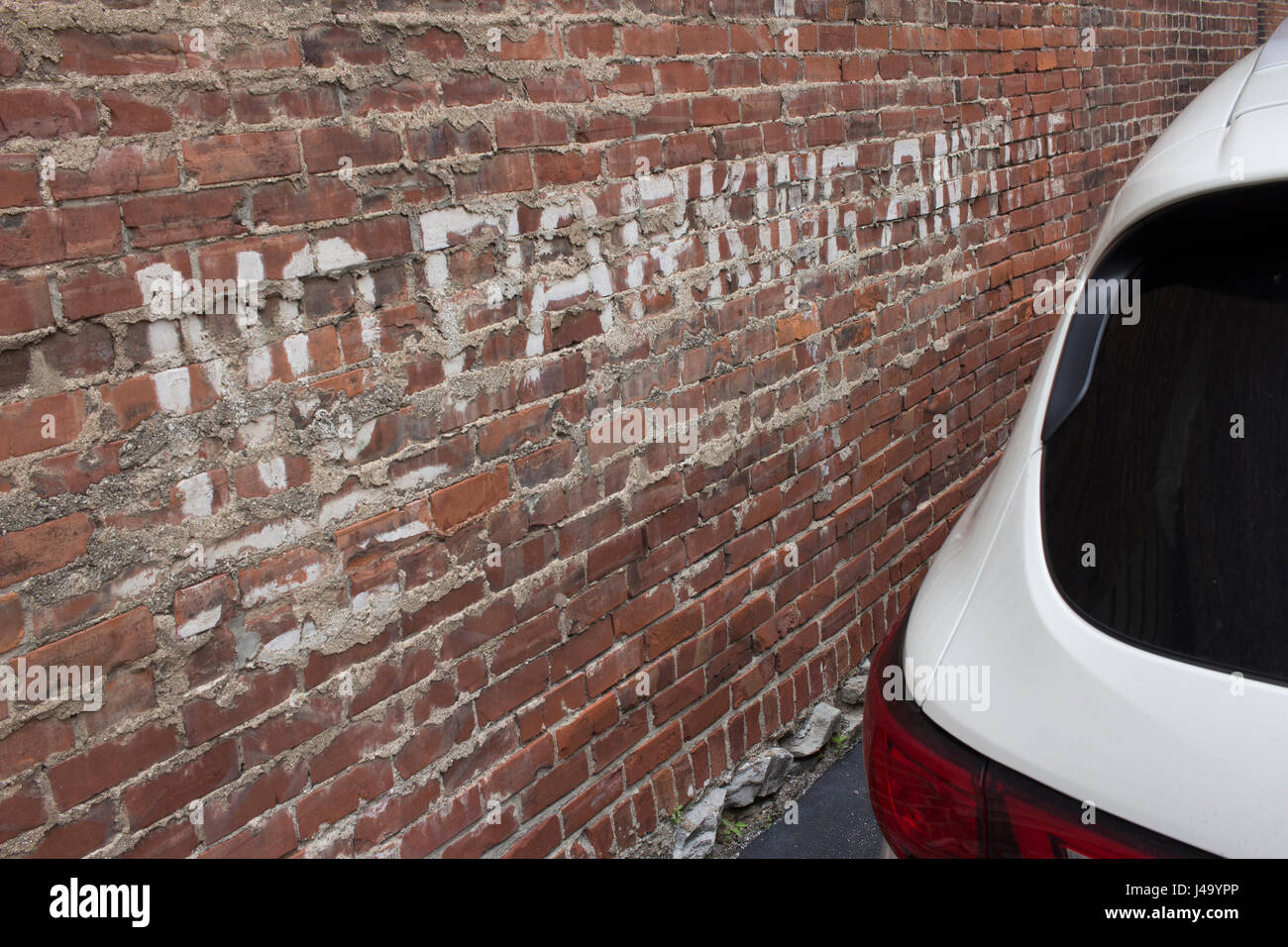 Nessun segno di parcheggio su rosso muro di mattoni con un suv bianco. Foto Stock