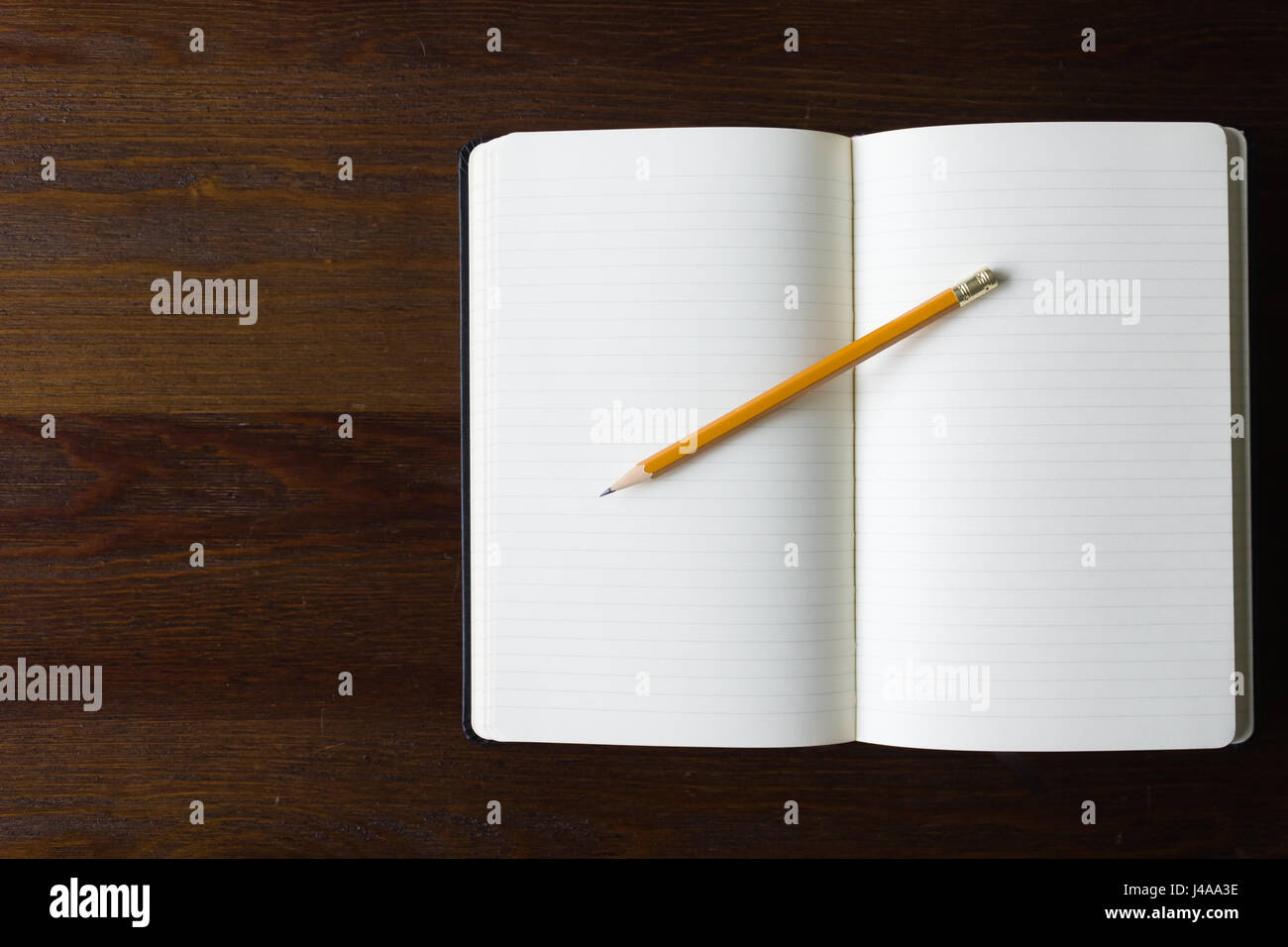 Un vuoto che ha governato il notebook e matita su un sfondo di legno Foto Stock