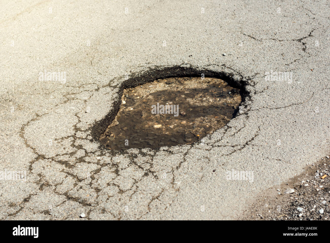 Strada asfaltata foro danni, in prossimità del viale di danneggiato Foto Stock