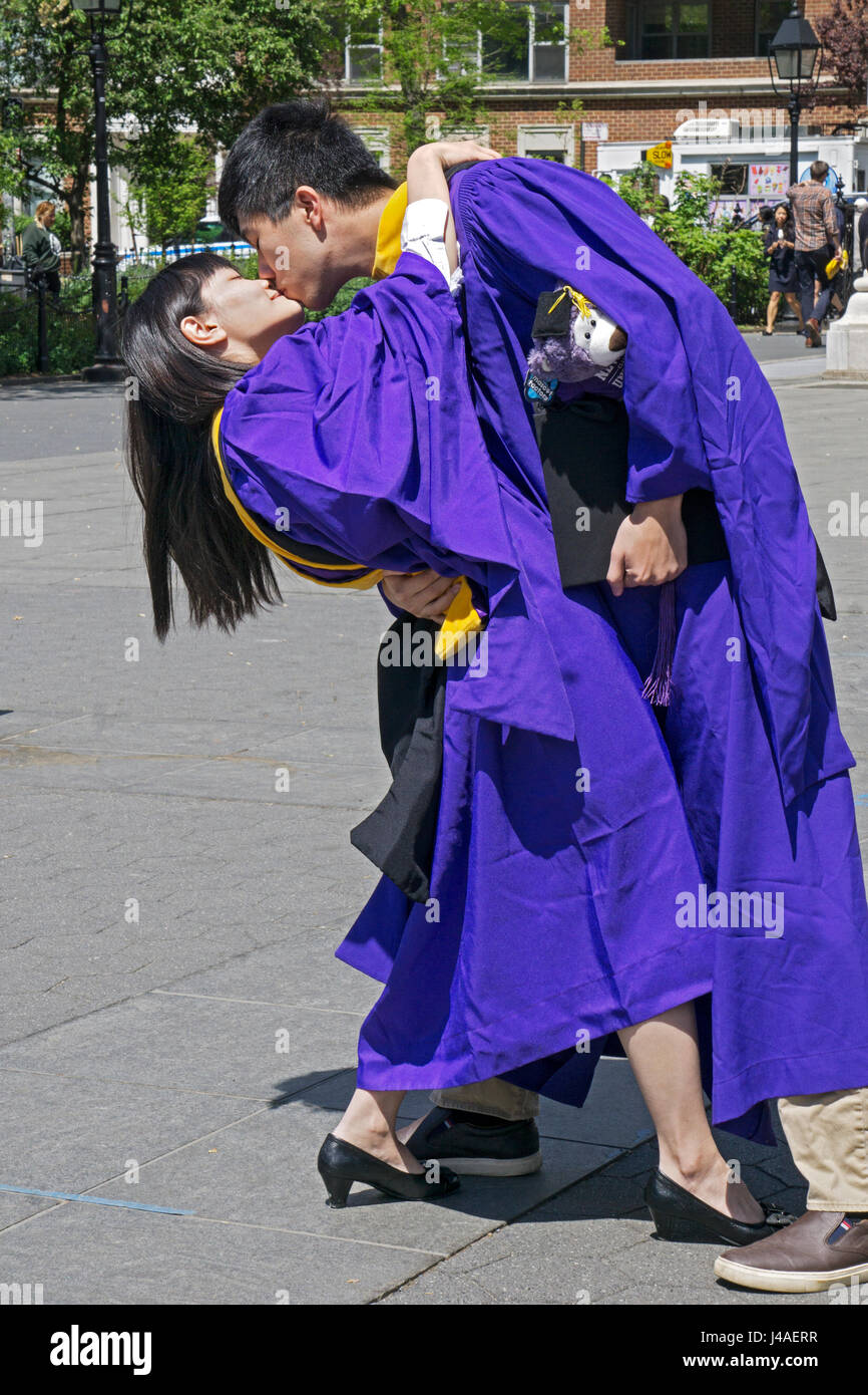 I laureati di Taiwan di NYU celebrare sempre loro master con un appassionato bacio in Washington Square Park nel Greenwich Village di New York City Foto Stock