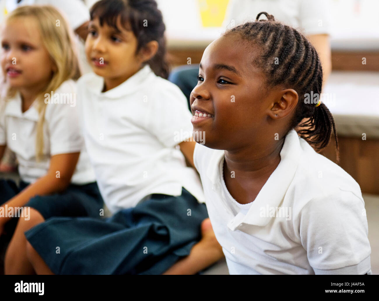 Kindergarten studenti seduti sul pavimento Foto Stock