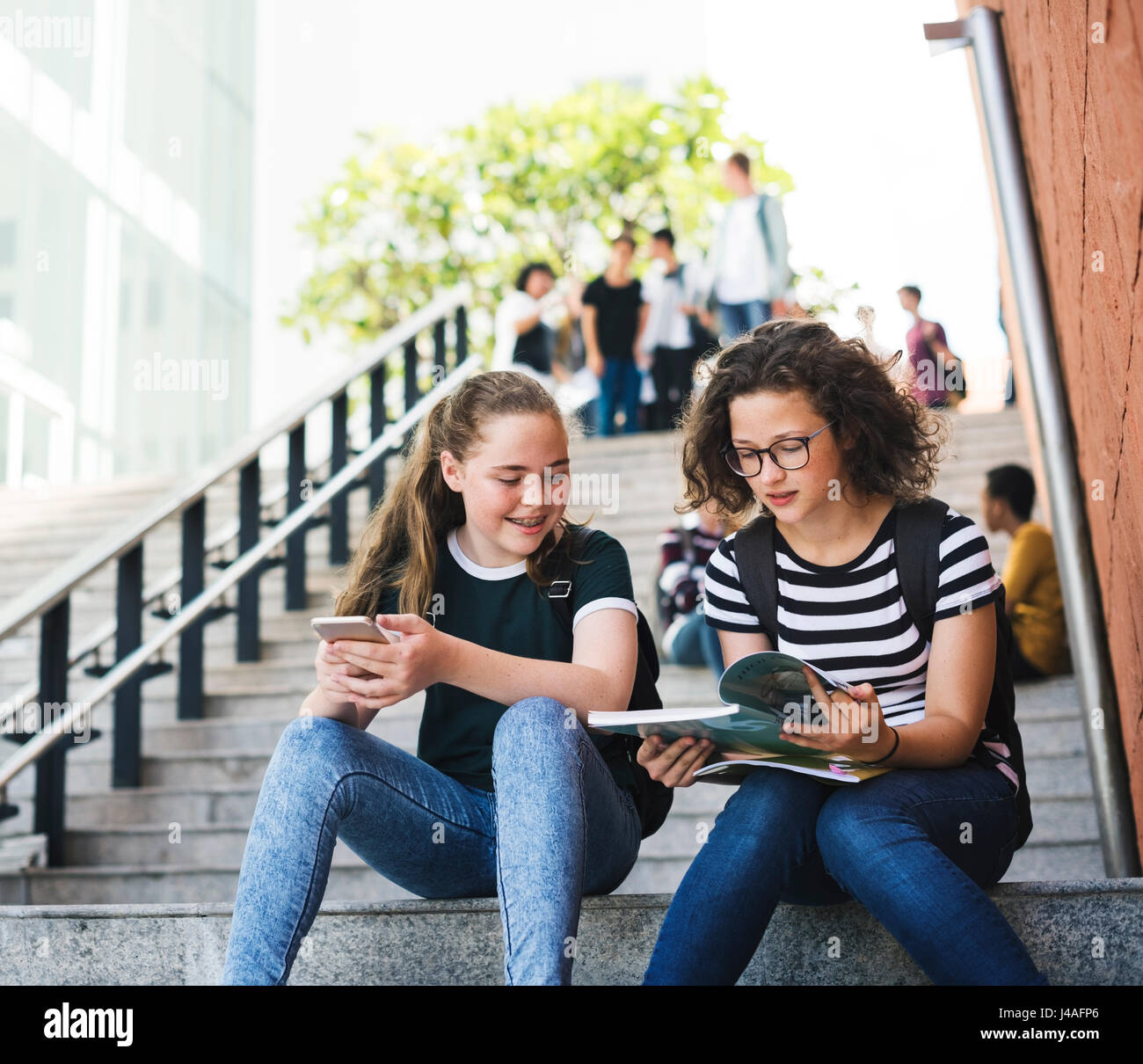 Gruppo di studenti seduti su scala utilizzando lptop Foto Stock