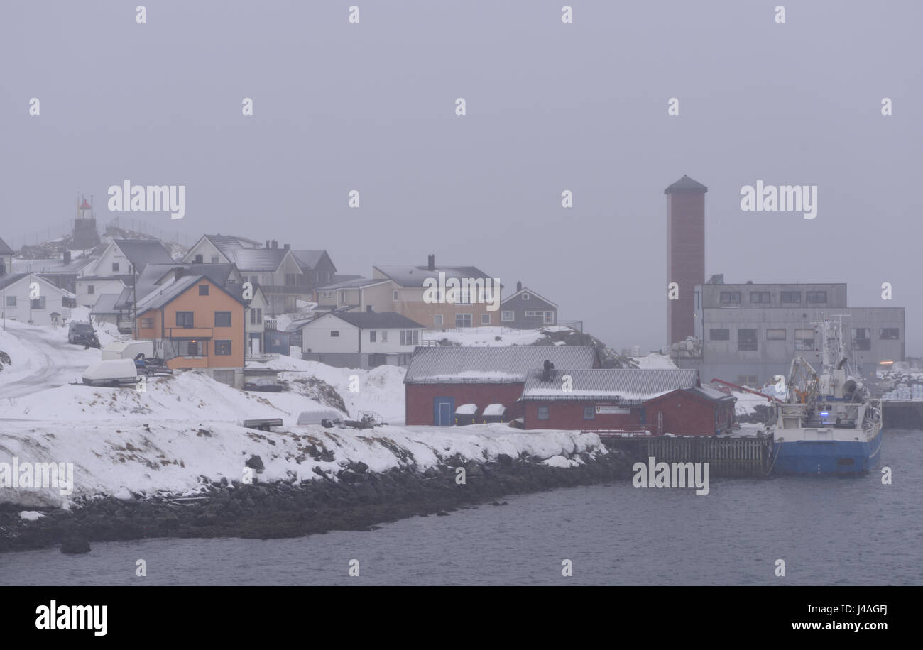 Il porto di Honningsvag, la città più settentrionale della Norvegia, in una nebbiosa mattina d'inverno. Sulla skyline sono il faro e un net torre di essiccazione. Foto Stock